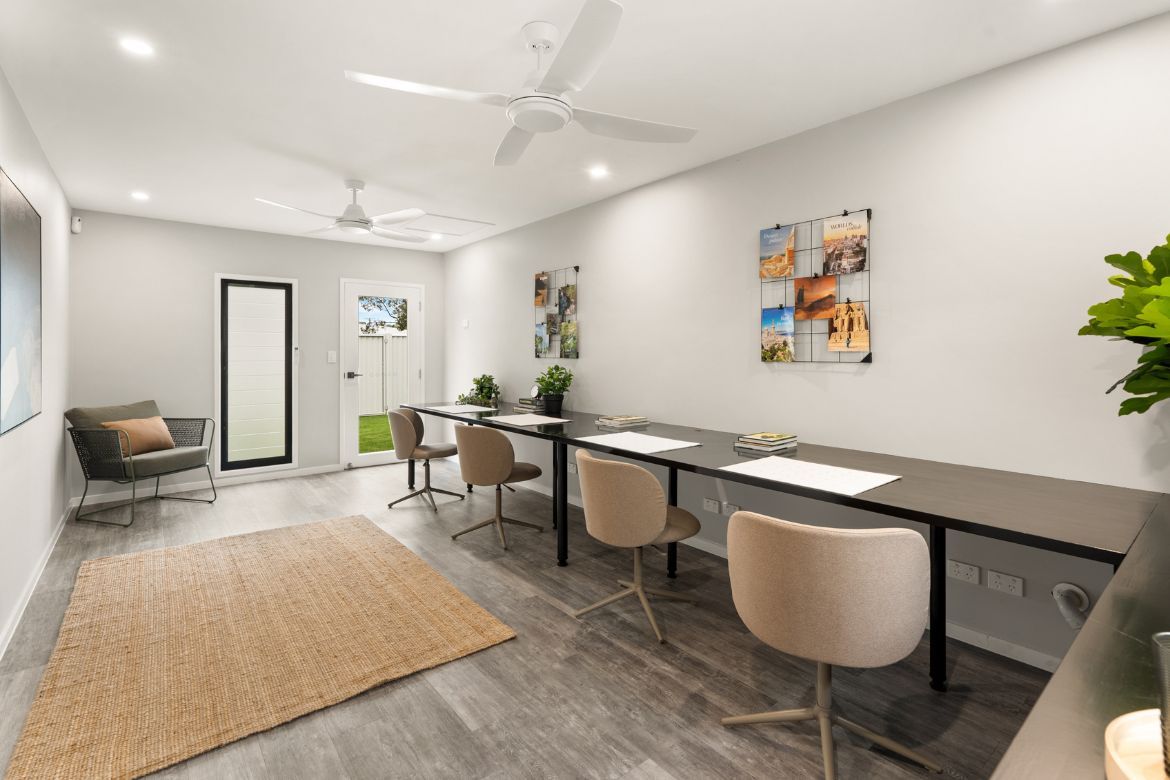 Separate air-conditioned home oCice at Prize Home 469 featuring a long workspace with multiple desks and seating.