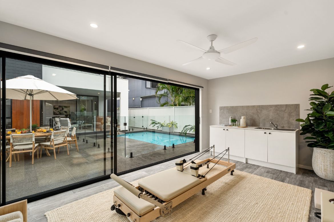 Poolside Pilates Studio at Prize Home 469 featuring a reformer, kitchenette and sliding doors overlooking the magnesium pool.