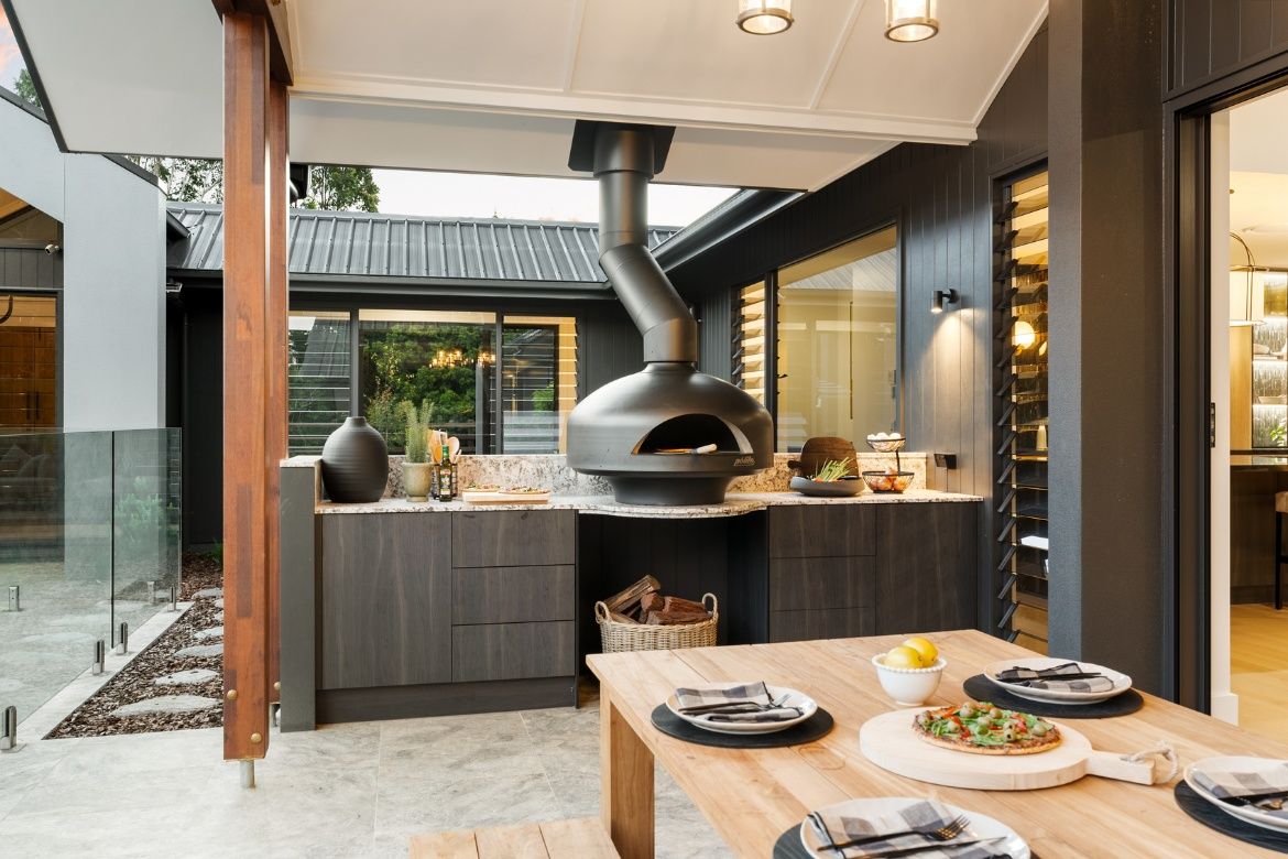 Covered outdoor entertaining area with a premium woodfired pizza oven, stone benchtops and alfresco dining space overlooking the courtyard