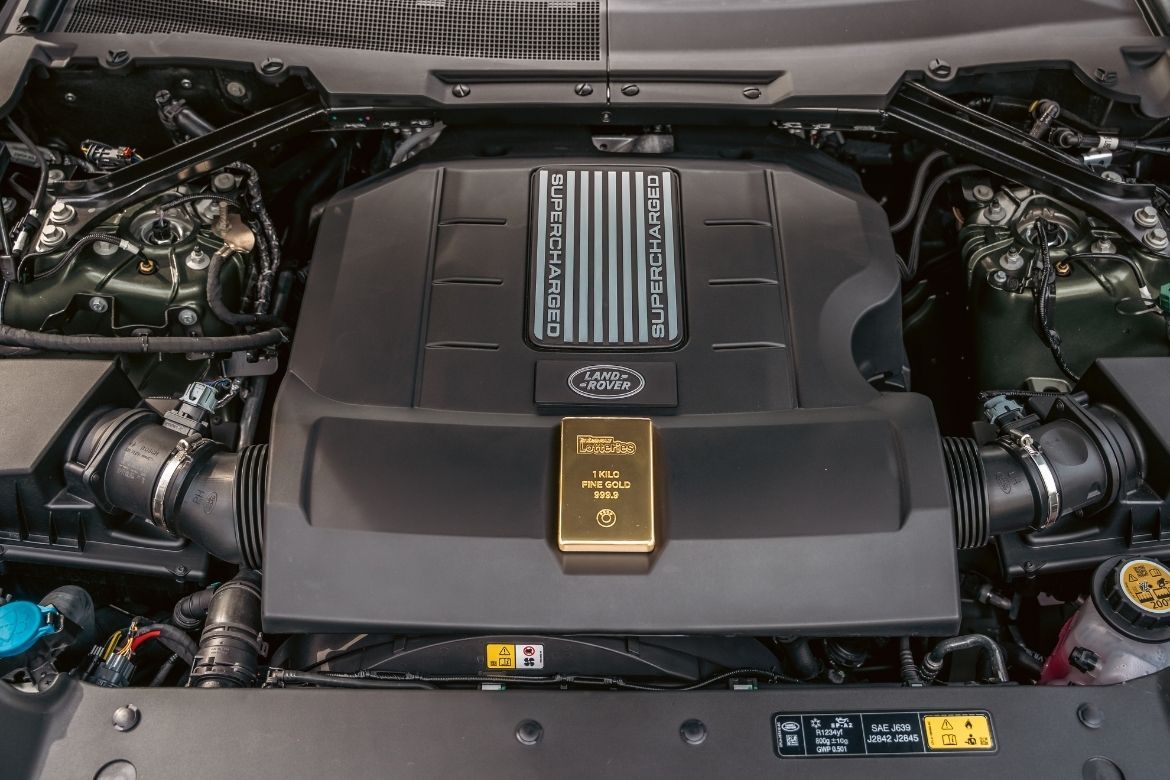 A 1kg gold bar representing $200k cashable gold prize displayed on the engine of a V8 Land Rover Defender
