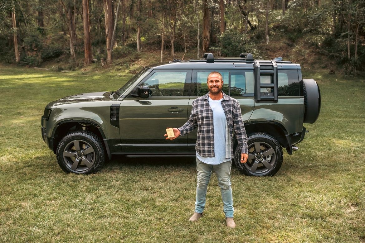 Person holding gold bar in front of the Defender
