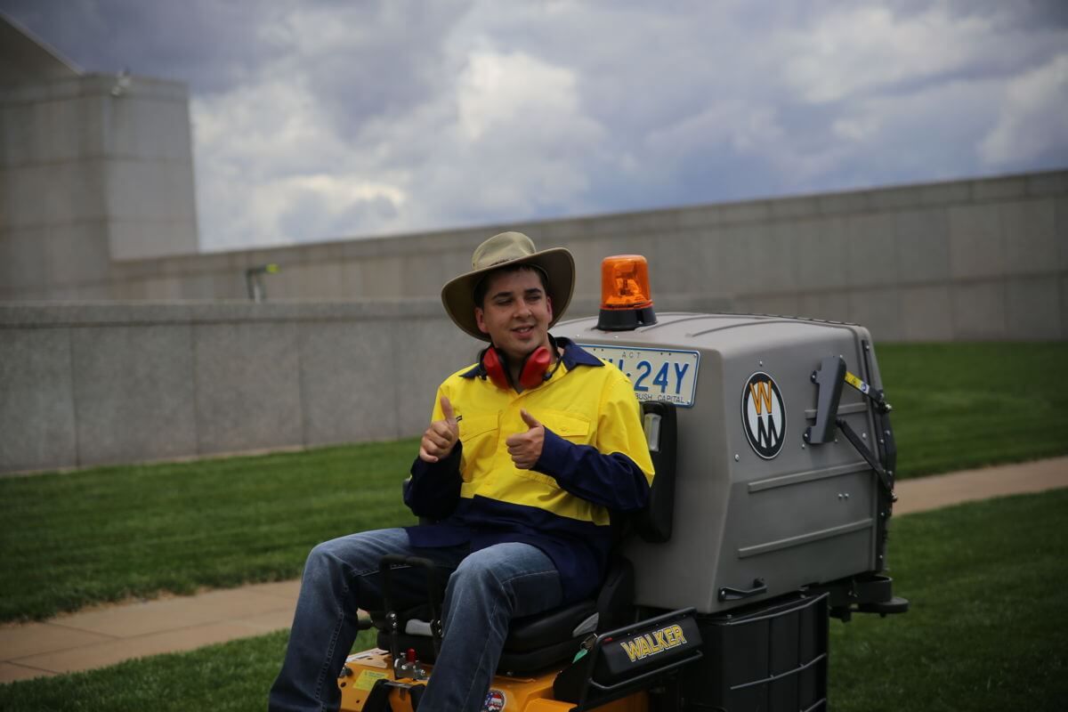 Photo of Joshua Ball mowing parliment house