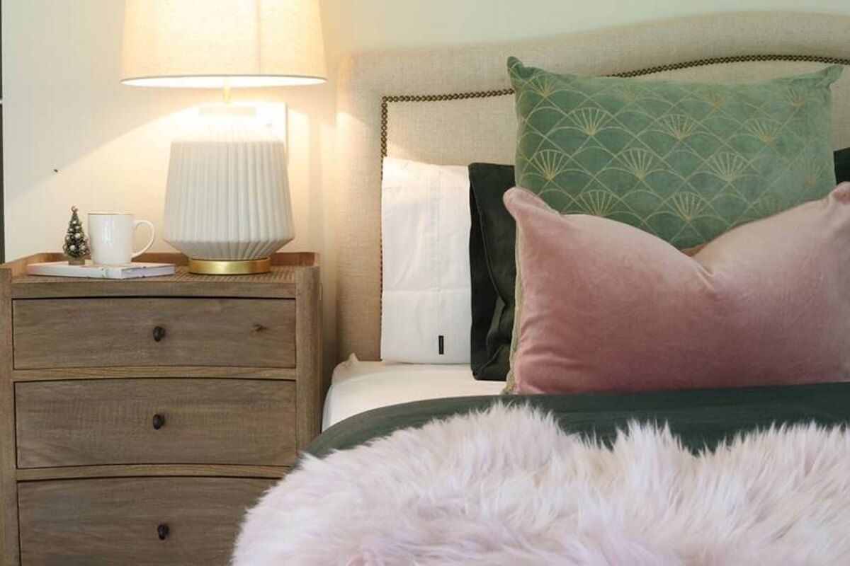 The master bedroom features a soft palette of shell pink and forest green