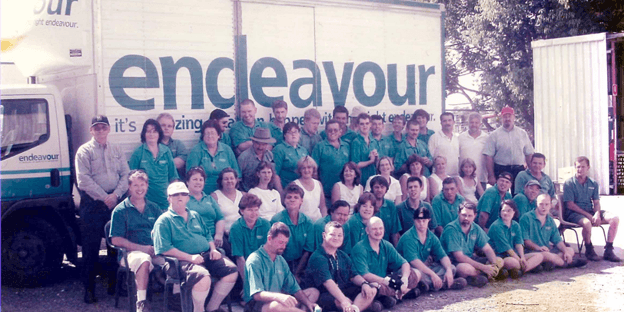 Historical group photo of Endeavour Foundation staff, supported employees and community members gathered in front of an Endeavour truck