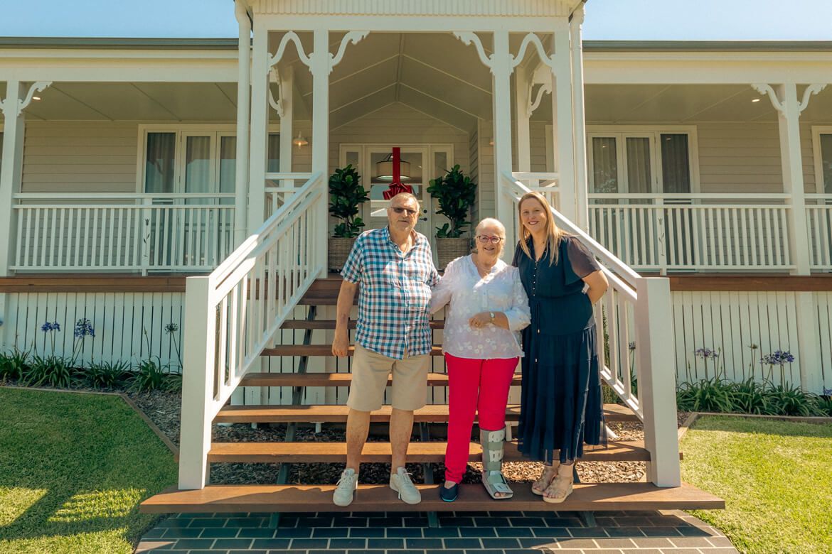 Winners stand on stairs outside of brand new Prize Home