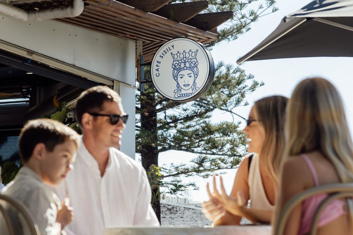 Family enjoying a relaxed meal together at a local café near Golden Beach on the Sunshine Coast.