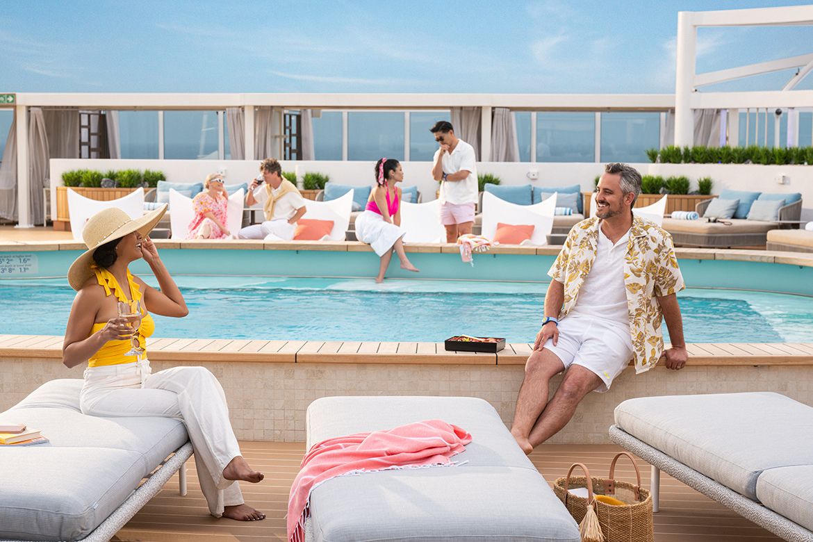 Travellers relaxing beside a swimming pool on a cruise ship.