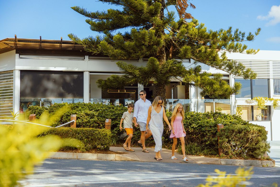 Family walking together through Golden Beach on their way to a local café.