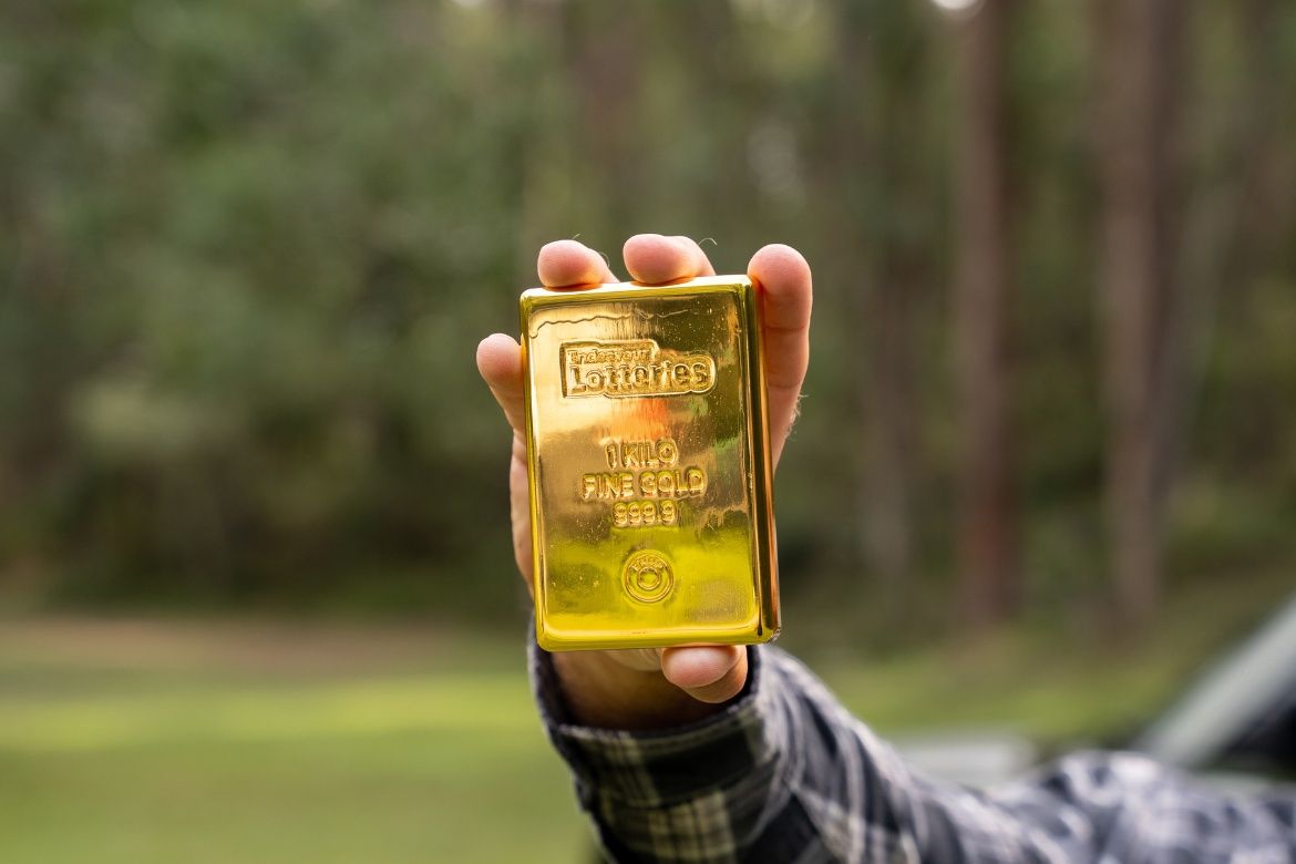 $200K cashable gold prize represented by a 1kg gold bar held in front of the camera