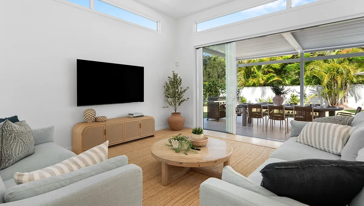 The light-filled living room of the Coolum Beach Prize Home opening onto a covered outdoor dining area.